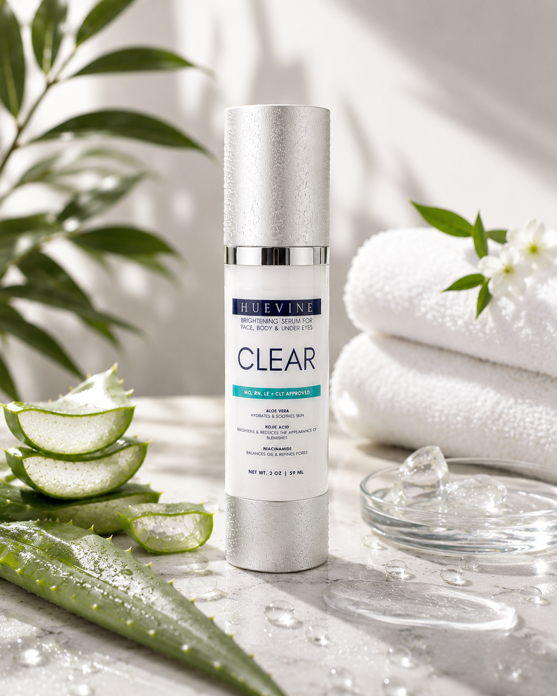 HueVine Clear Brightening Serum displayed with spa towels, aloe vera, and skincare ingredients.
