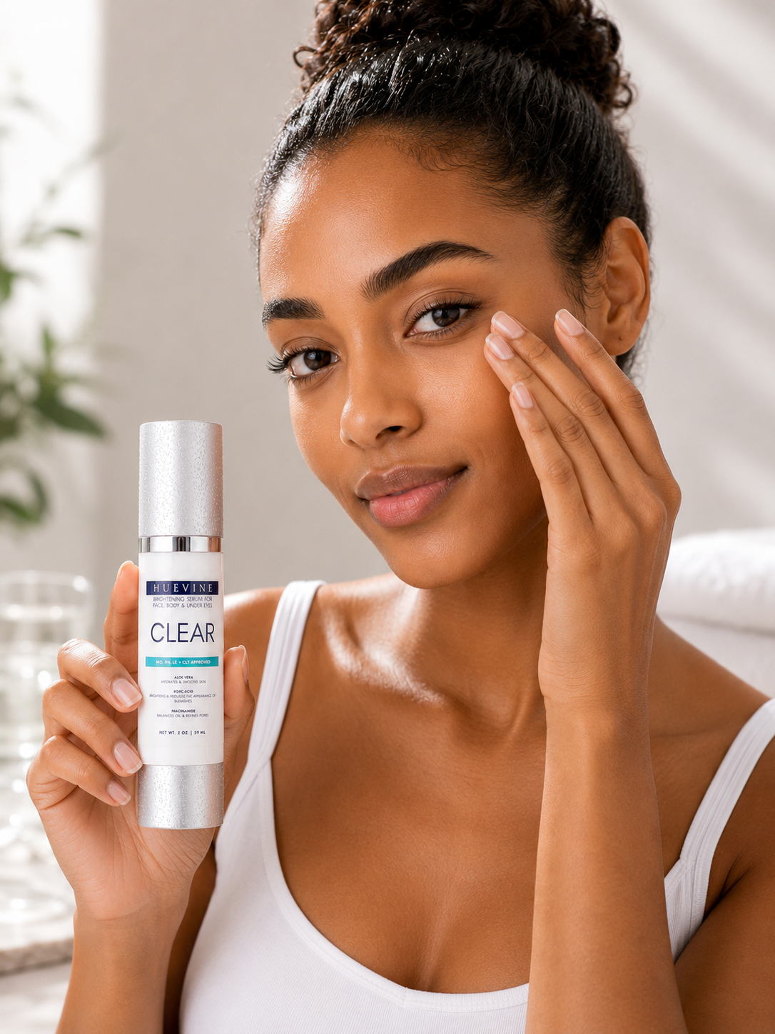 Woman applying HueVine Clear Brightening Serum during a skincare routine for brighter, more even-looking skin.