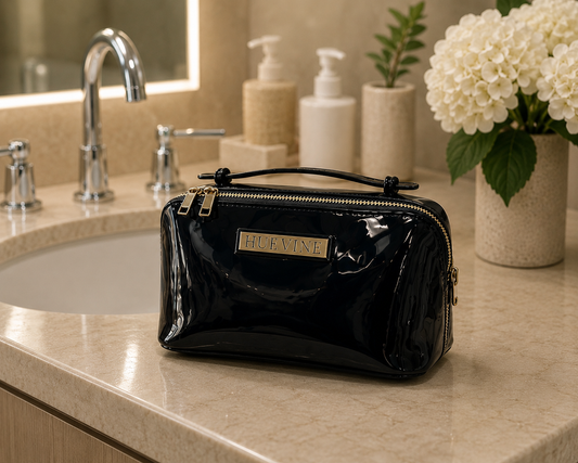 HueVine Glow Bag displayed on a luxury bathroom counter beside a sink in an elegant skincare setting.