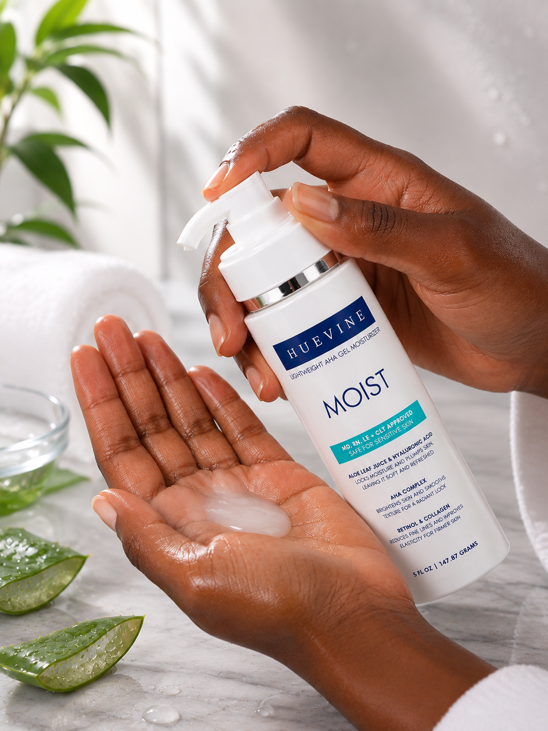 Close-up of HueVine MOIST lightweight AHA gel moisturizer being dispensed from a pump bottle onto the hand.