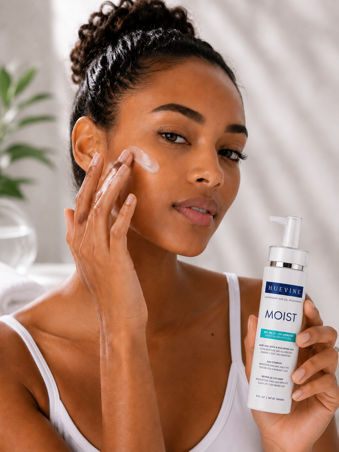 Person applying HueVine MOIST lightweight AHA gel moisturizer during a daily facial skincare routine.