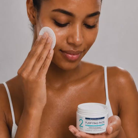 Person demonstrating application of a HueVine Purifying Pad during a facial skincare routine.