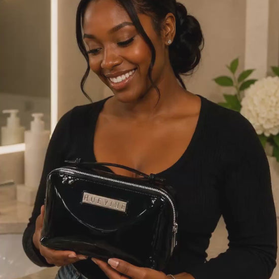 Woman holding the HueVine Glow Bag in a luxury bathroom setting.