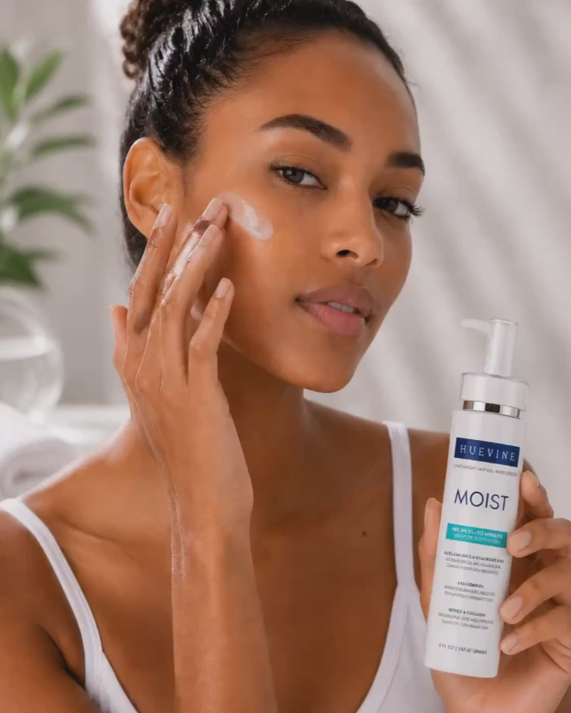 Person demonstrating application of HueVine MOIST lightweight AHA gel moisturizer as part of a facial skincare routine.